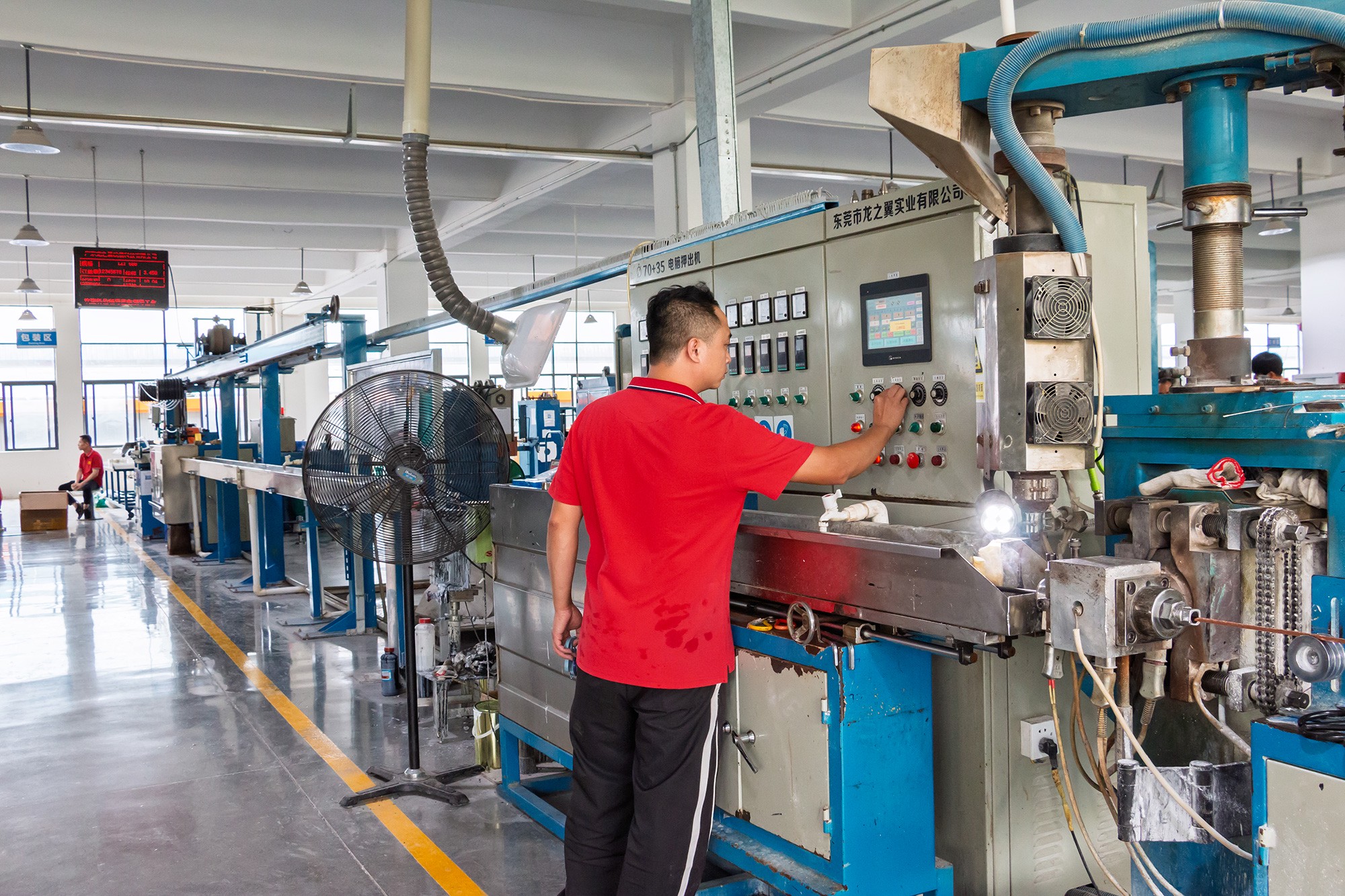 Worker Adjusting Extrusion Equipment
