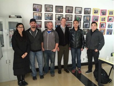 The owner of Yangbang Machinery poses for a photo with a customer in his office.