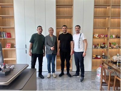 Le propriétaire de Yangbang Machinery pose avec un client dans son bureau.