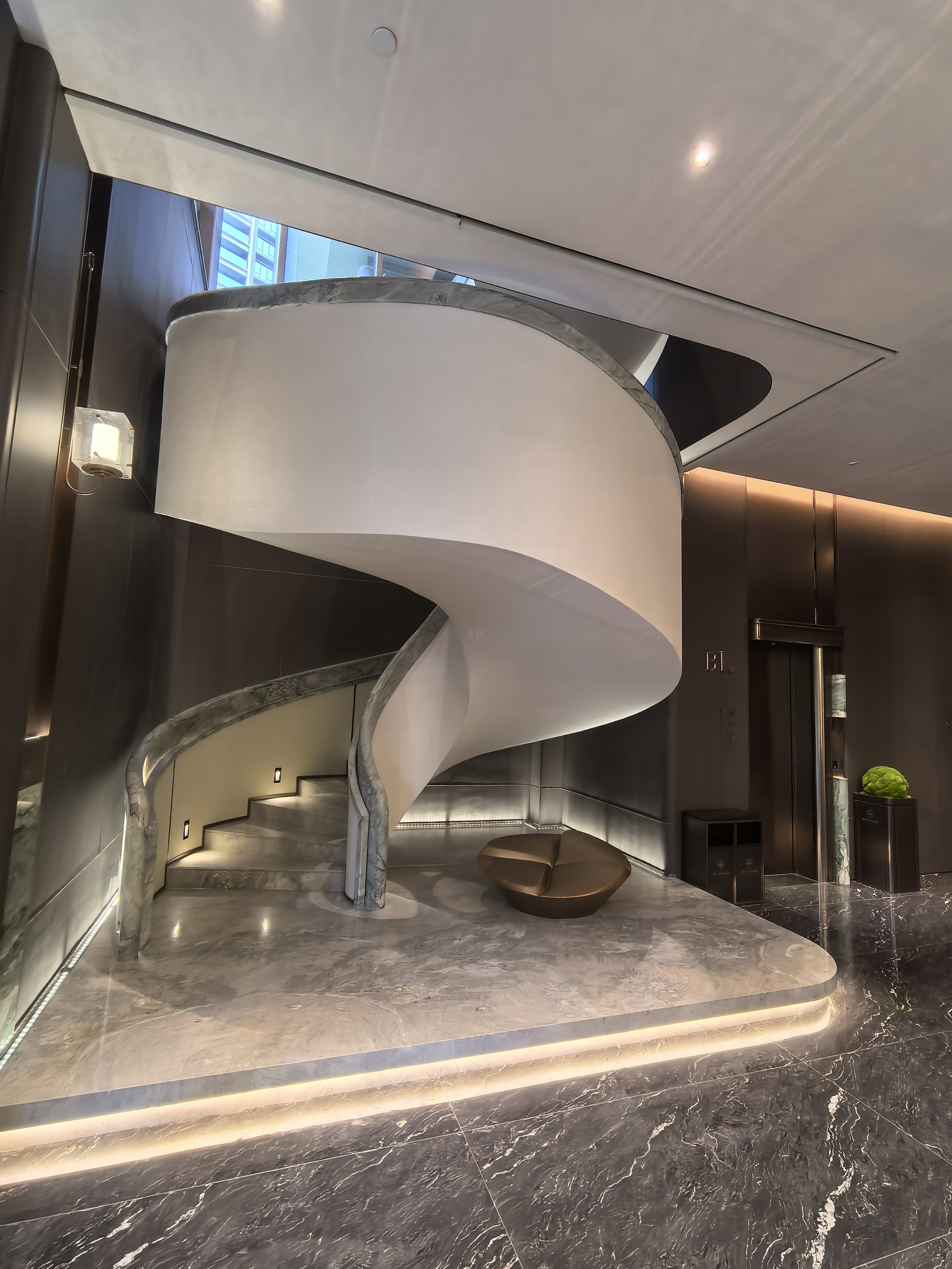 Grand marble spiral staircase with LED lighting in luxury residence