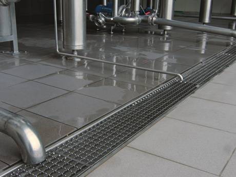 A serrated press-locked steel grating placed on the ground for drainage in a factory..jpg