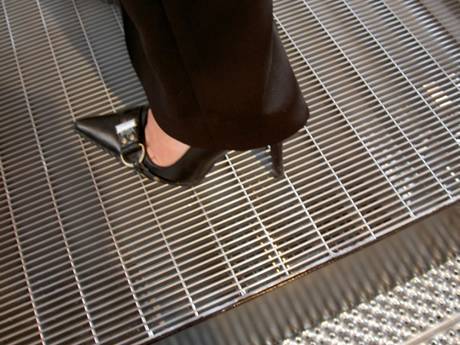 One foot wearing black high heel standing on dense steel grating without falling..jpg