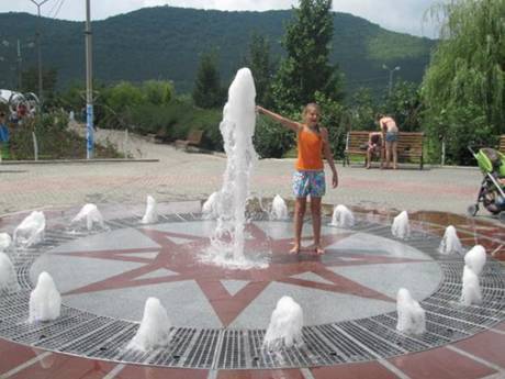 A girl is playing on the square with fountain..jpg