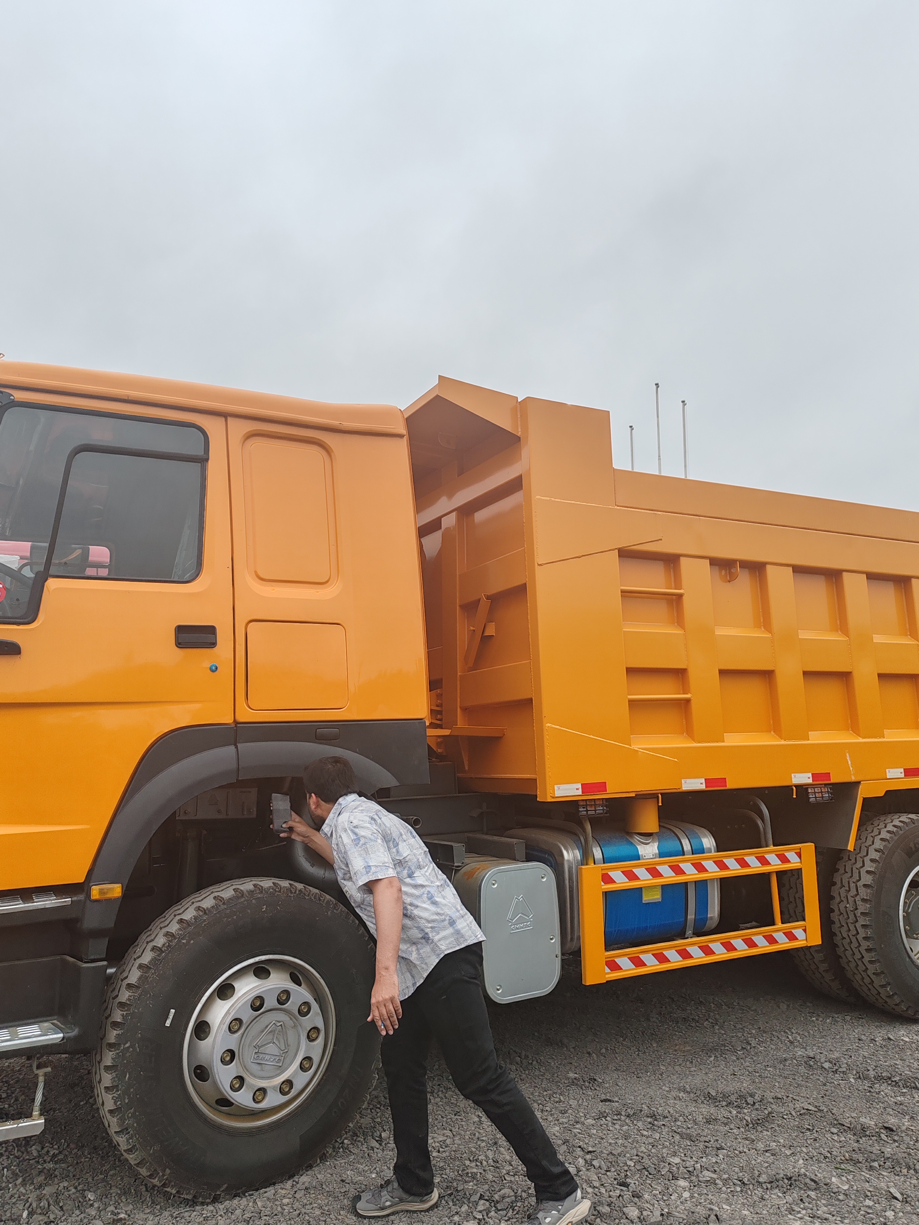 An Afghan Customer Inspects Used Dump Trucks