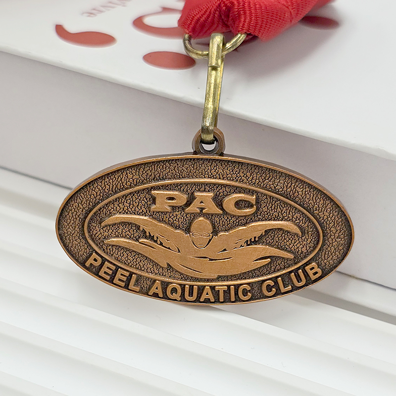 Retro bronze oval metal medal, swimming-themed relief from a water sports club, collectible ornament for water sports events.