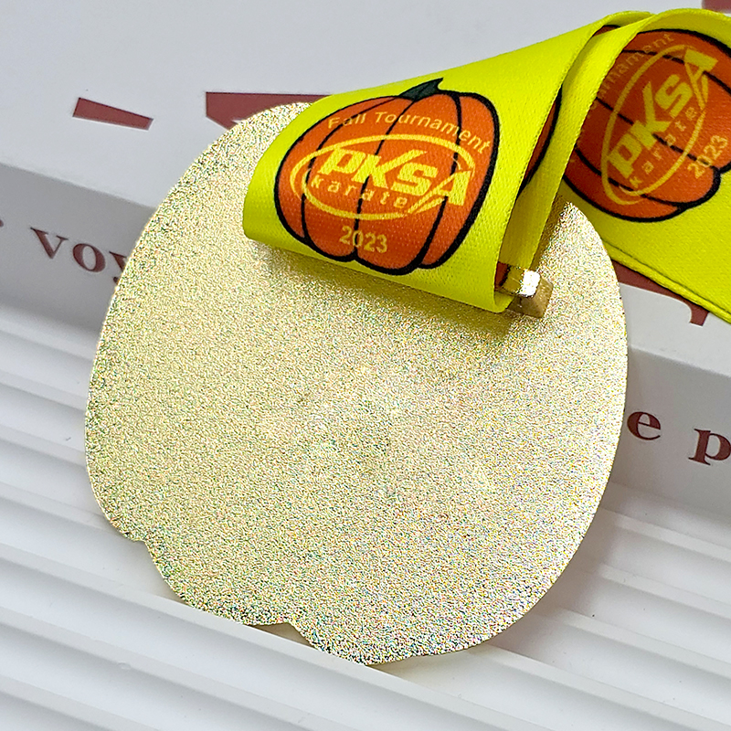 Orange and gold color-blocked pumpkin-shaped metal medal, commemorating the 2023 PKSA Karate Autumn Championships, Halloween-themed collectible item.