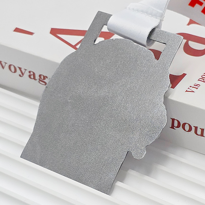 Silver and blue two-tone metallic medal, commemorating the 2018 Turgoyak Triathlon, featuring a 3D relief of a lake outline, a collectible item from a Russian outdoor sports event.