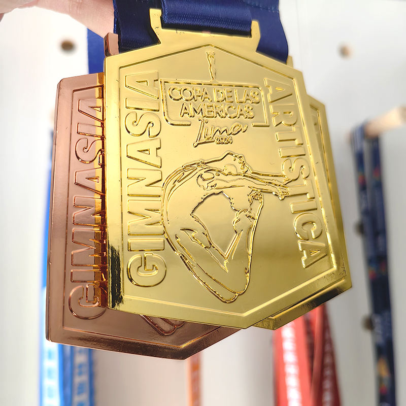 Gold, silver, and bronze medals at the Lima American Rhythmic Gymnastics Championships; medals featuring uniquely shaped gymnastics formations.