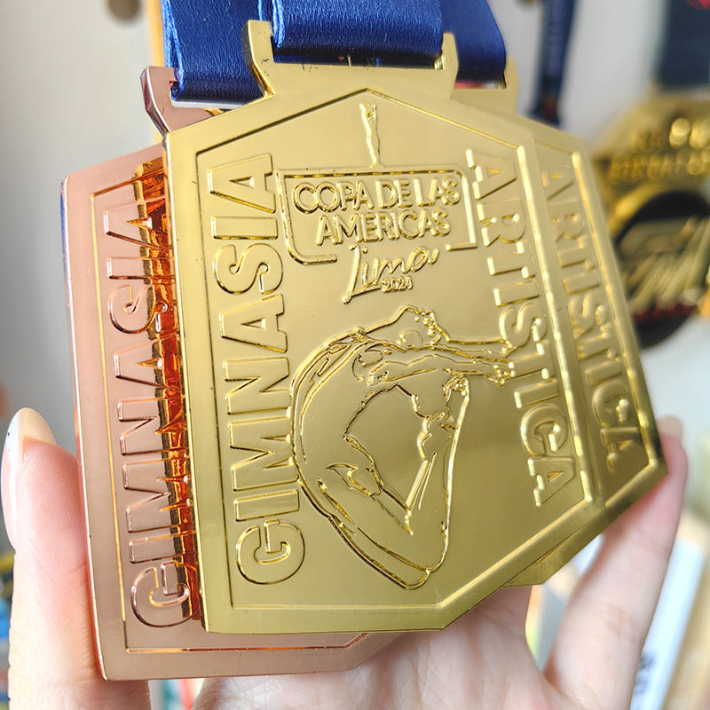 Gold, silver, and bronze medals at the Lima American Rhythmic Gymnastics Championships; medals featuring uniquely shaped gymnastics formations.
