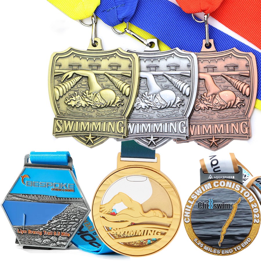 A collection of swimming medals: Gold, Silver, and Bronze shield-shaped / hexagonal / circular relief swimming commemorative badges.