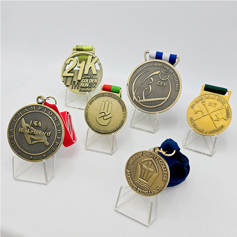 Una colección de medallas metálicas en varios estilos, que cubren eventos como carreras, voleibol y esquí acuático. Con un acabado vintage en oro, plata y bronce, estos son artículos conmemorativos coleccionables para eventos deportivos.