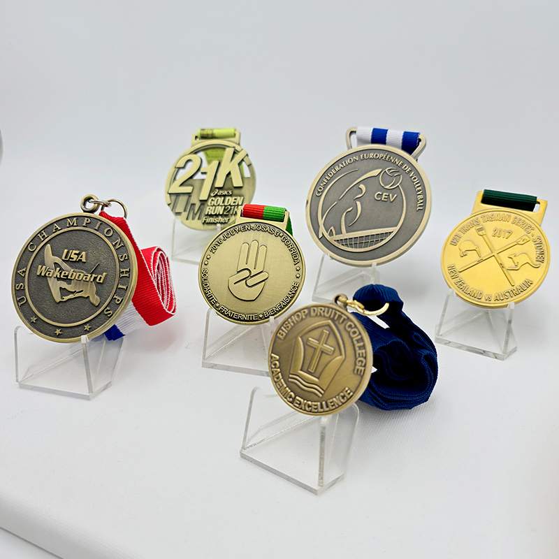 Una colección de medallas metálicas en varios estilos, que cubren eventos como carreras, voleibol y esquí acuático. Con un acabado vintage en oro, plata y bronce, estos son artículos conmemorativos coleccionables para eventos deportivos.
