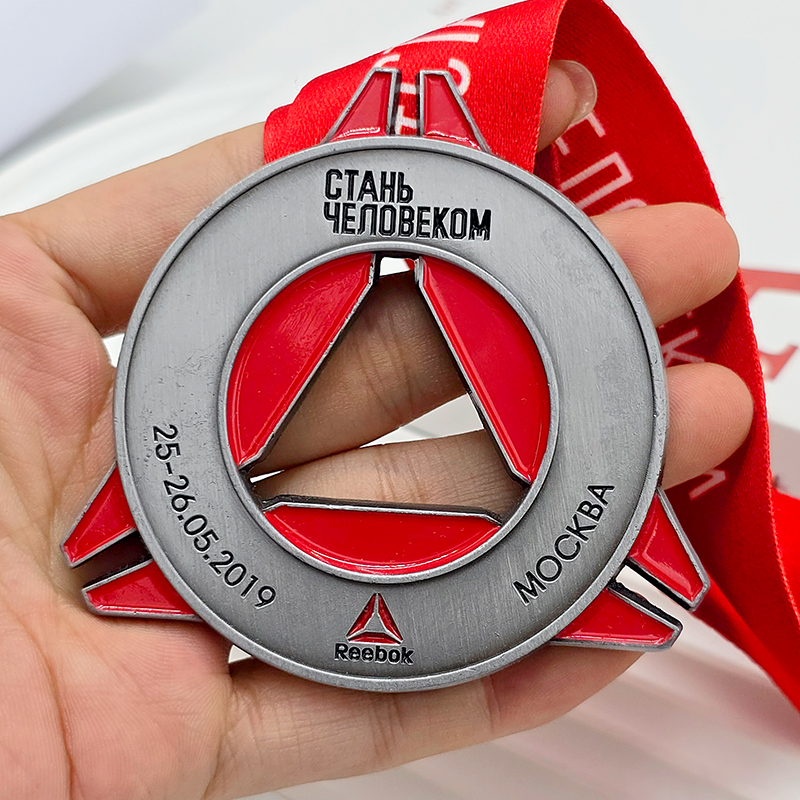Medalla de metal en contraste plateado y rojo, anillo conmemorativo de la carrera Reebok de Moscú con relieve calado triangular en forma de anillo, artículo coleccionable de eventos deportivos.