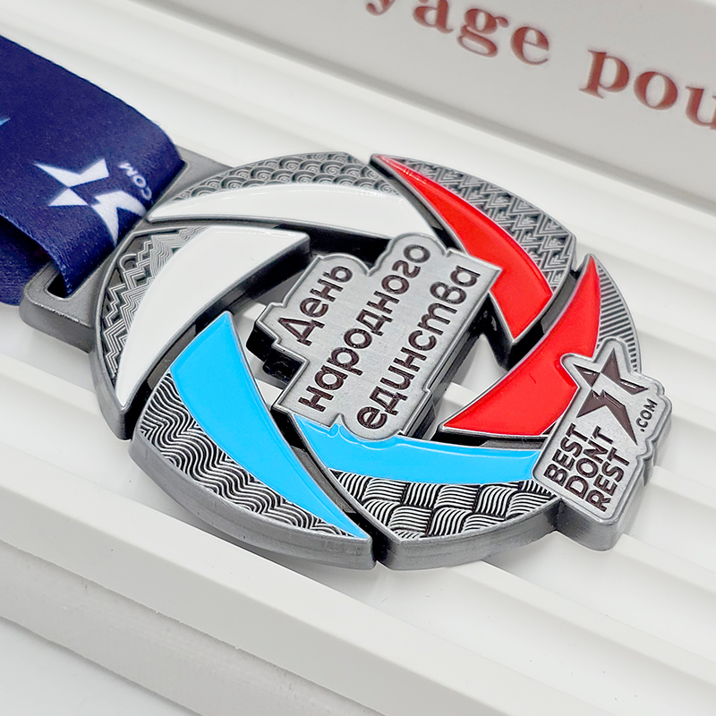 Medalla metálica con bloques de color plateado, rojo y azul; insignia conmemorativa temática del 