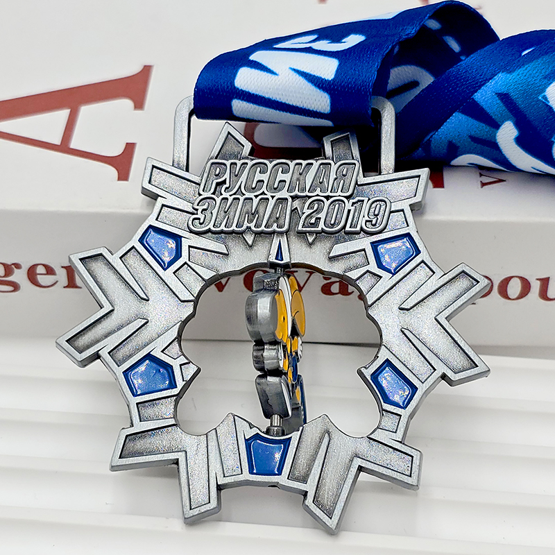 Medalla metálica con forma de copo de nieve en colores plateado y azul, conmemorativa de los Juegos de Invierno de Rusia 2019; relieve 3D de un esquiador de dibujos animados; objeto coleccionable con temática invernal.