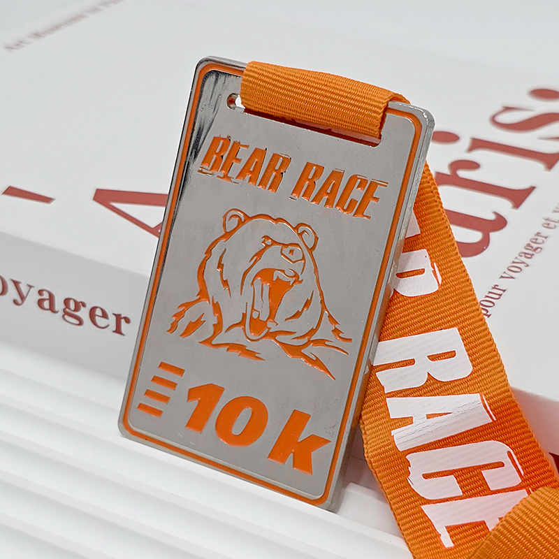 Silberne und orangefarbene metallische Medaille mit Farbblockung, 3D-Bärenkopf-Relief zur Erinnerung an den 10K-Lauf, ein Sammlerstück für Läufer, die das Rennen beendet haben.