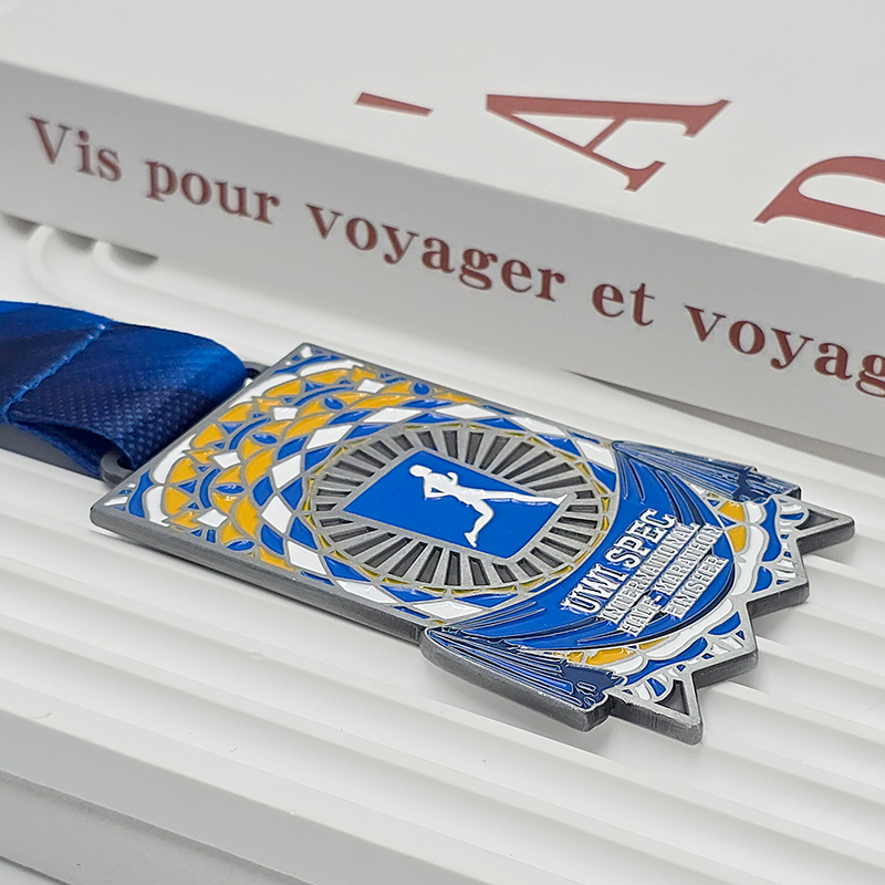 Silberne, blaue und gelbe Metallmedaille mit Farbblockdesign, Erinnerungsstück für Finisher des UWI SPEC International Half Marathon, Relief mit Mosaikmuster, Sammlerstück für Karibik-Läufe.