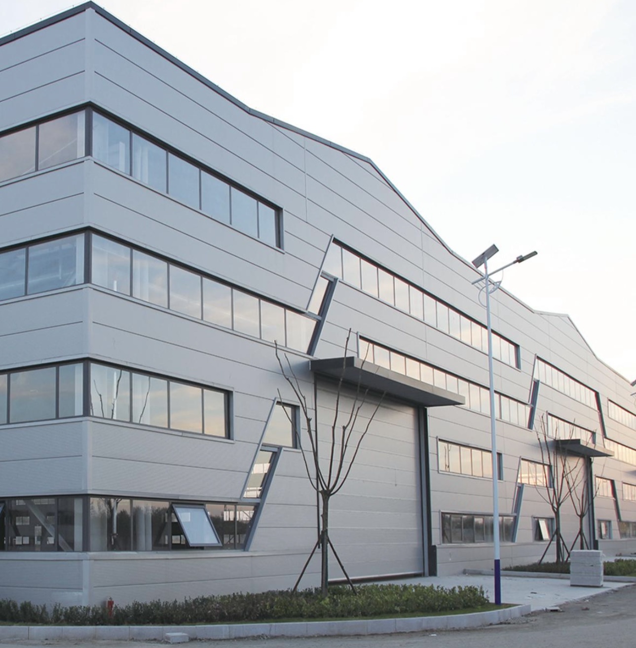 Multi-story factory building with creative folded-line design and colored steel cladding
