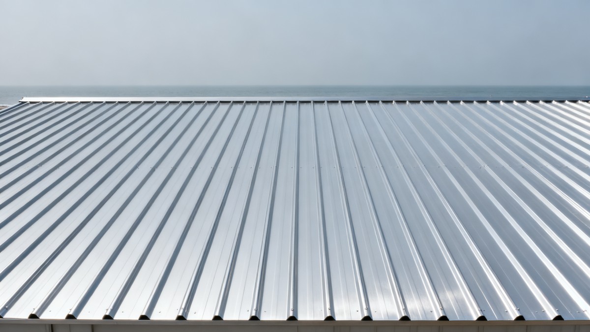 What benefits does steel roofing offer over asphalt shingles in coastal areas