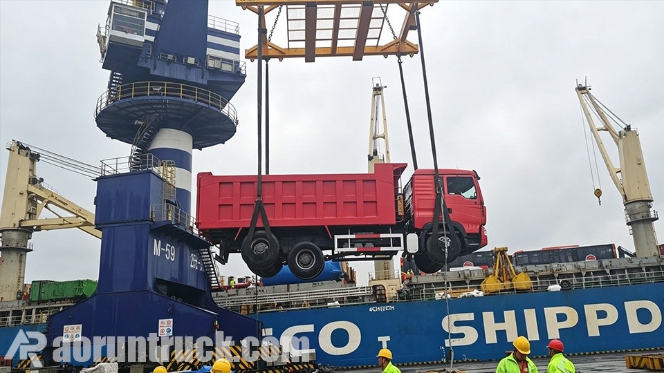 Camions-bennes SINOTRUK HOWO TX 6x4 bicolores stationnés au port pour expédition maritime vers la République du Congo