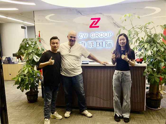 African clients group photo at ZW Group headquarters entrance: building trust for semi-trailer and truck export to Africa.