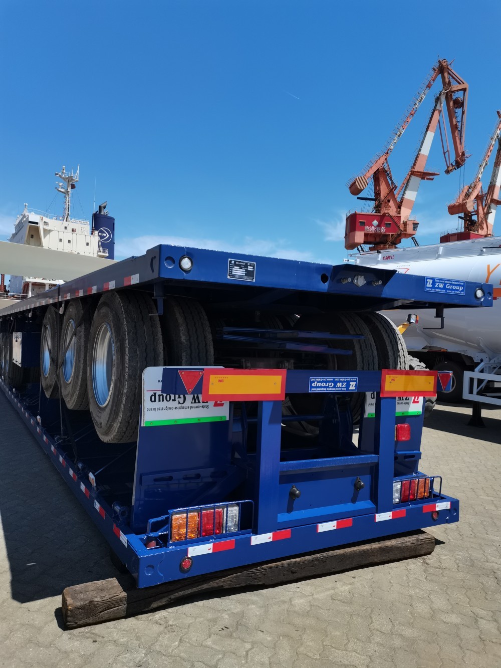 3 axle 53FT flatbed semi trailer ready for shipment at port yard, factory packing completed, container loading and heavy duty export logistics scene