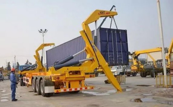 Container side loader crane in action, lifting ISO container from ground to truck chassis, showcasing hydraulic lifting system, stability stabilizers, and precise container handling for efficient port logistics operations