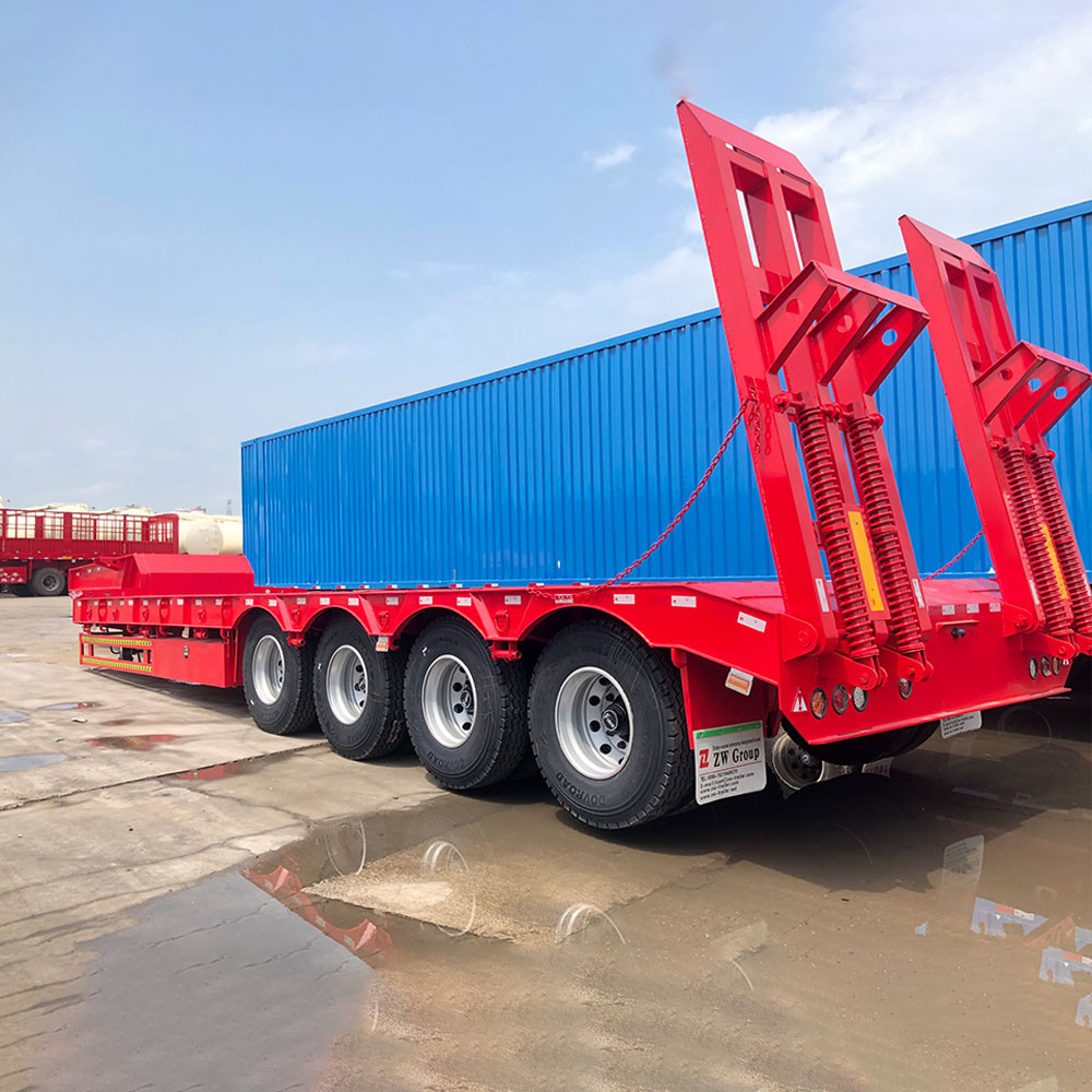 4 axle 100 ton lowbed semi trailer rear three quarter view showing heavy-duty loading ramps and rear frame