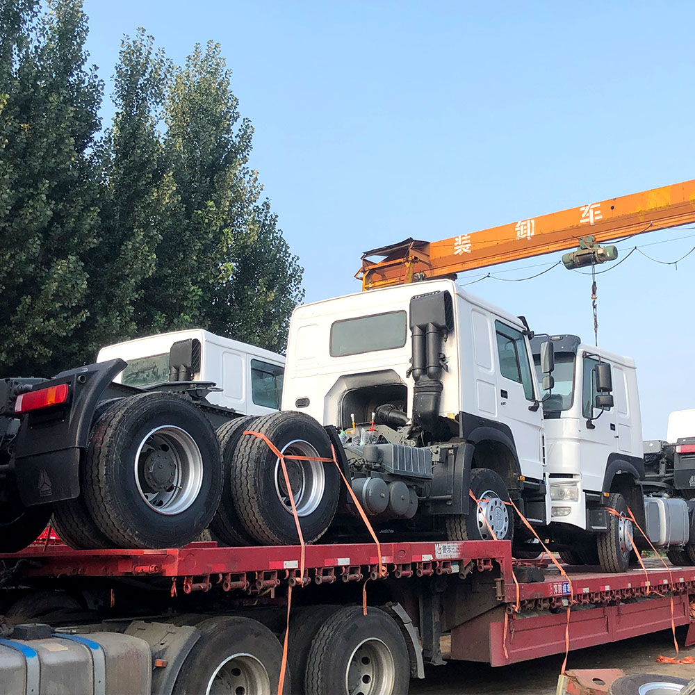 Fleet of HOWO tractor trucks for export: dozens of heavy-duty trucks heading to the port for international shipping.