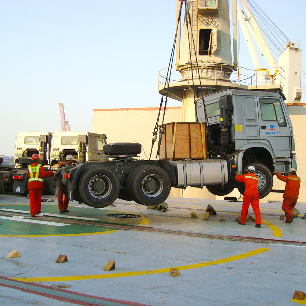 Shacman 6x4 tractor truck hoisted at port: ZW Group supplying heavy duty transport solutions globally.