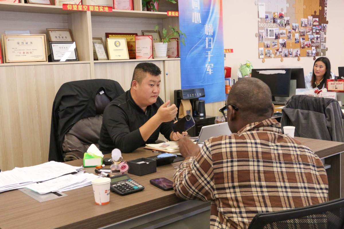 Senegalese transport operators discussing ZW Flatbed Trailers and HOWO Trucks' technical specifications, highlighting key factors like cargo capacity, fuel efficiency, and operational uptime.