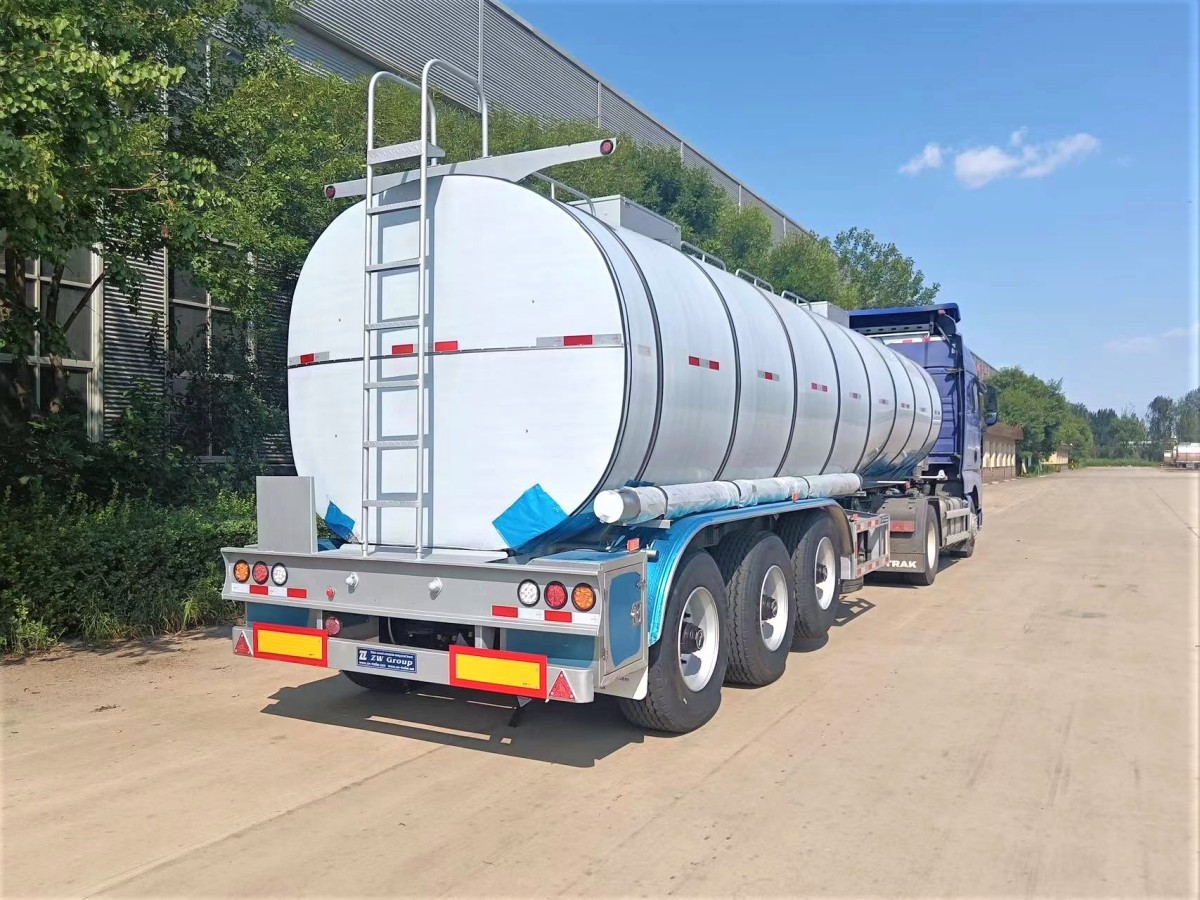 3 axle stainless steel tanker trailer rear three quarter view showing discharge system and rear platform