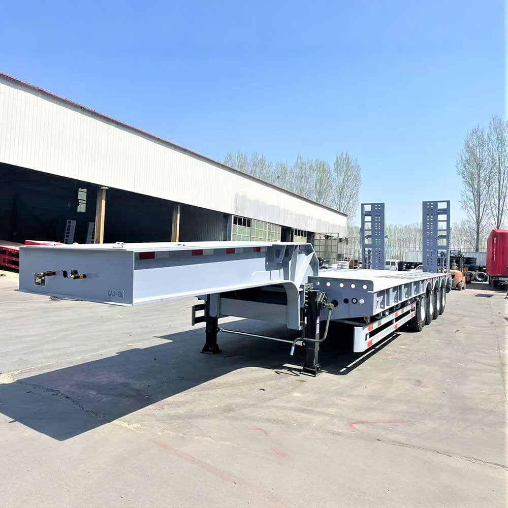 4 axle 100 ton lowbed semi trailer front three quarter view highlighting low deck height and heavy-duty axle layout