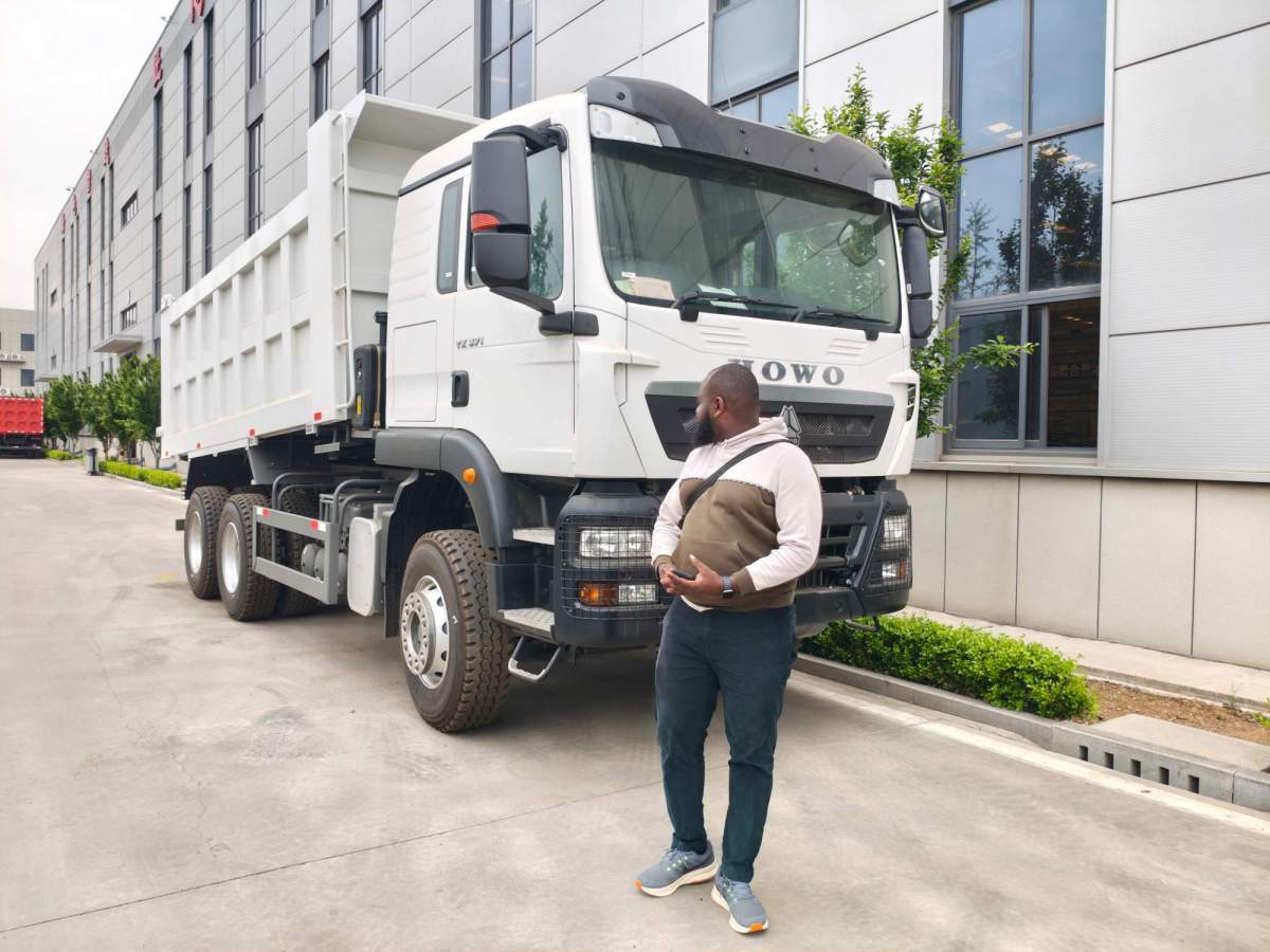 A Rwandan fleet owner inspecting a white HOWO TX dump truck at the ZW Group manufacturing facility before finalizing purchase.