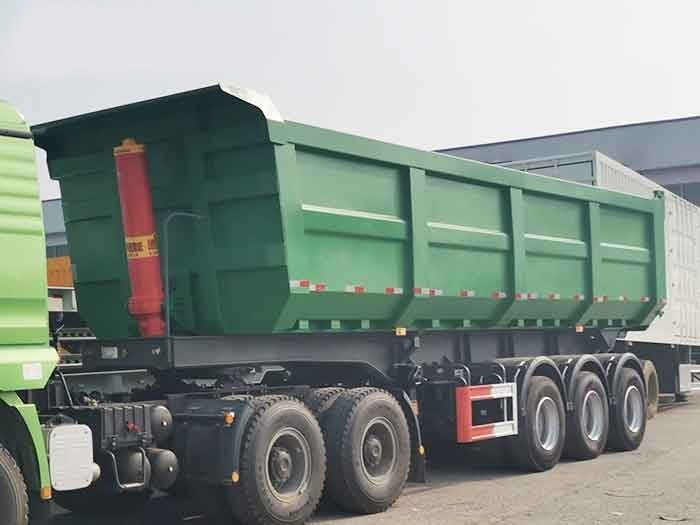 33CBM end dump semi trailer front three quarter view highlighting hydraulic cylinder and axle layout