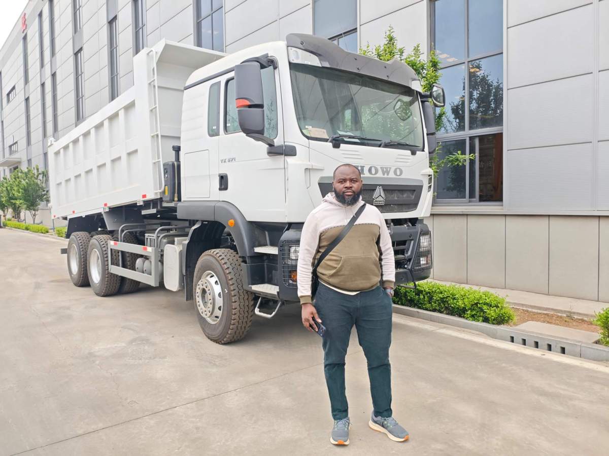 A Rwandan fleet owner inspecting a white HOWO TX dump truck at the ZW Group manufacturing facility before finalizing purchase.
