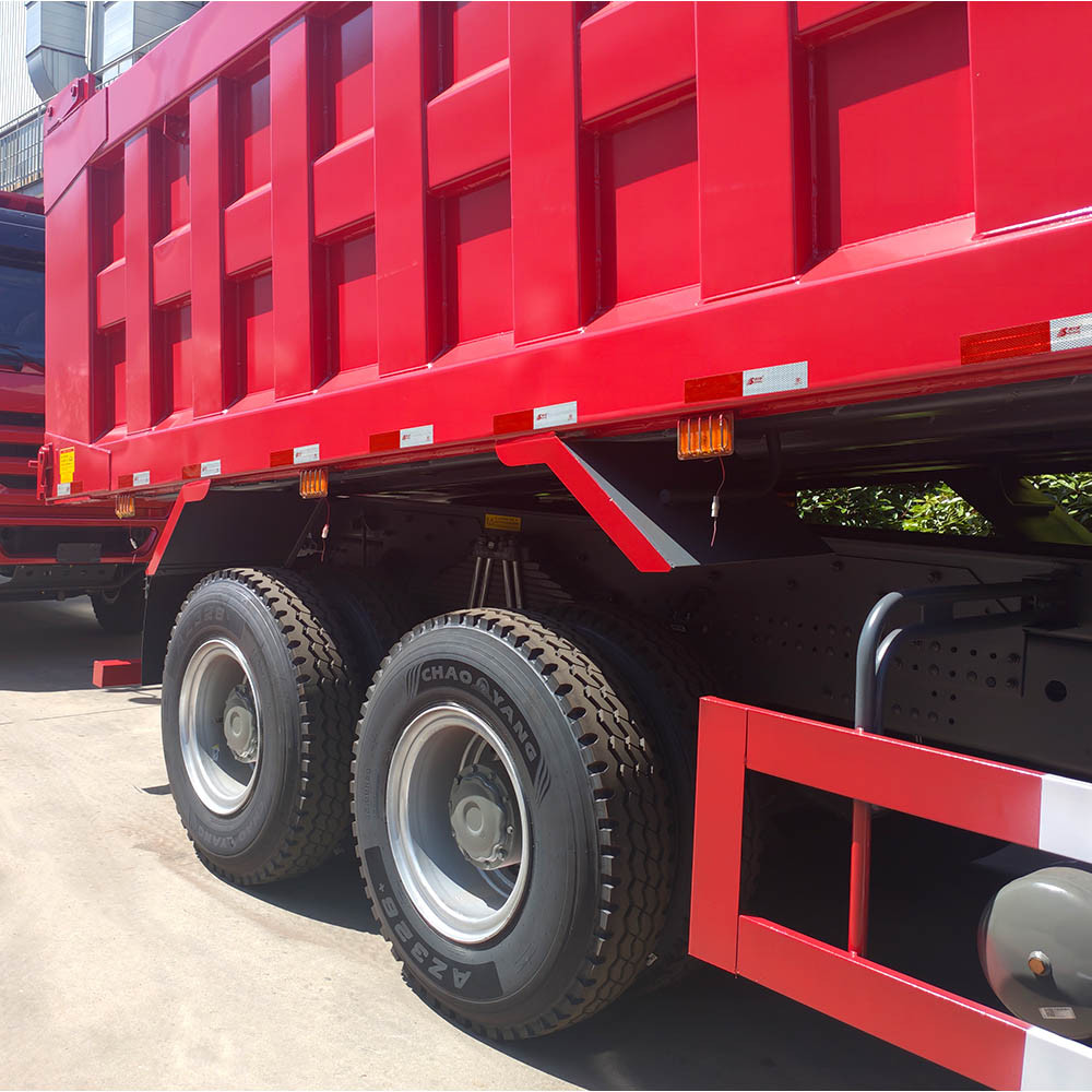Close-up dos pneus para serviço pesado, eixos traseiros e estrutura da caçamba de carga do caminhão basculante HOWO 6x4