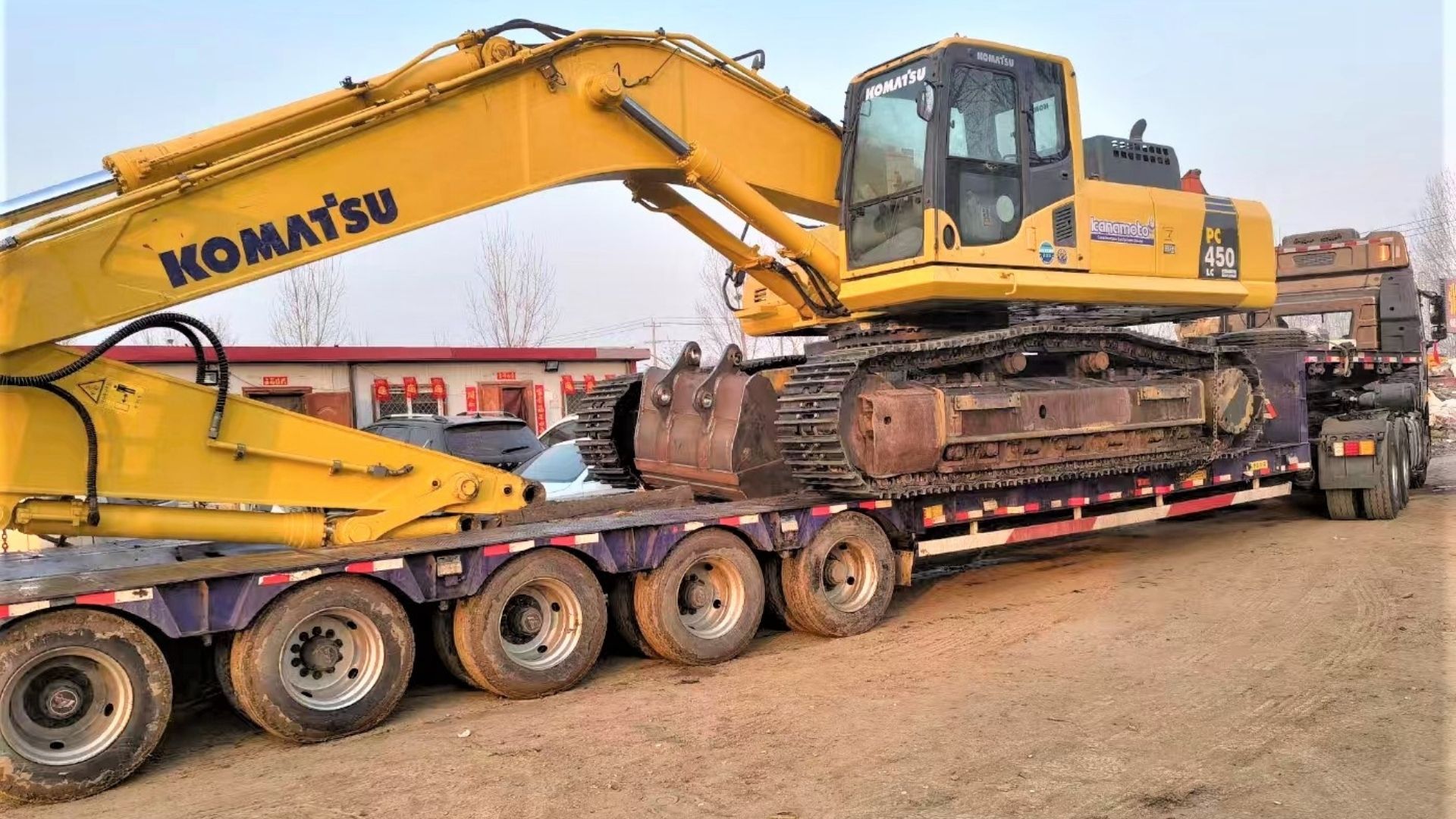 Remolque Lowbed de servicio pesado de ZW Group cargando una excavadora grande: alta capacidad de carga y chasis reforzado para el transporte de equipos de construcción.