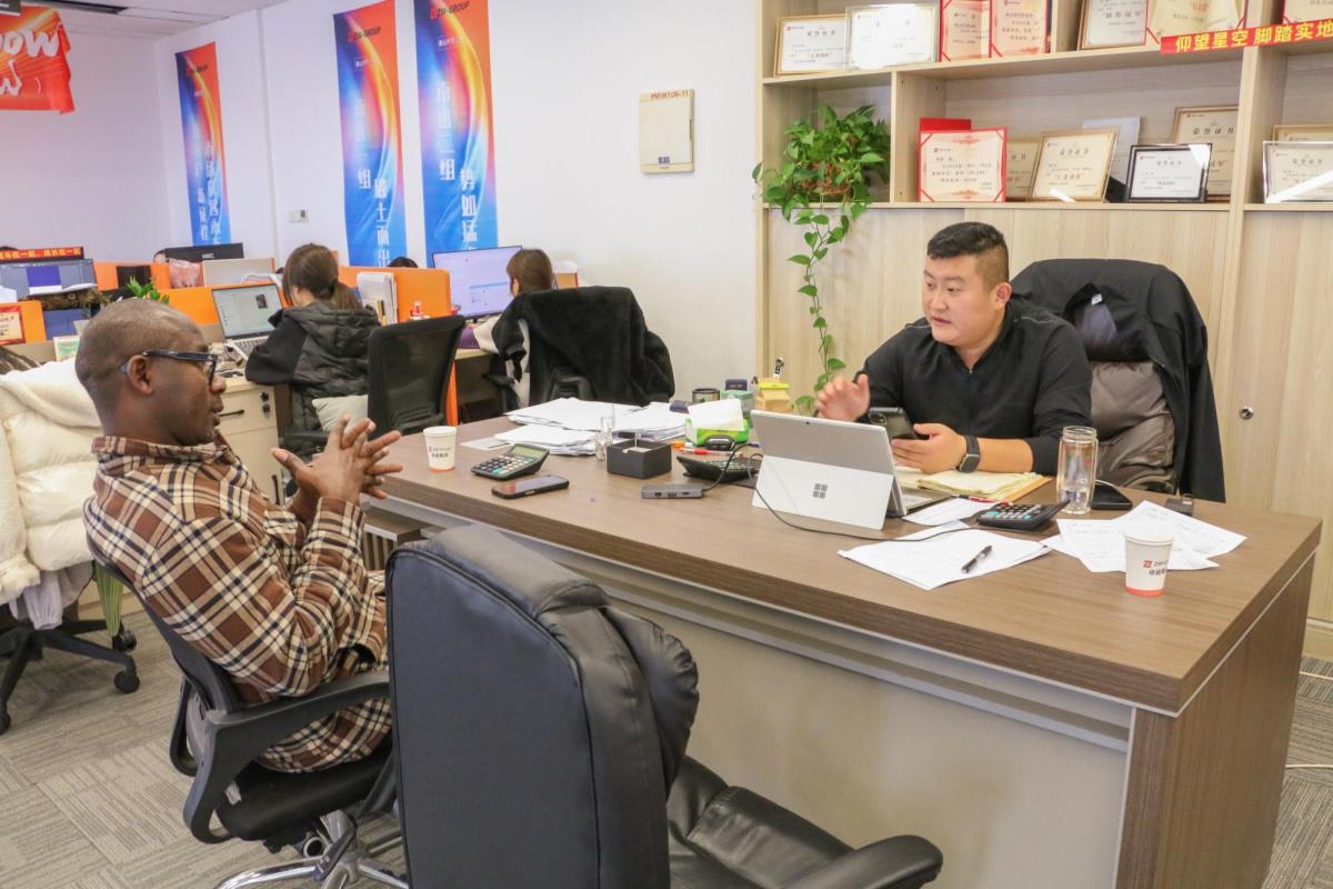 Senegalese transport operators discussing ZW Flatbed Trailers and HOWO Trucks' technical specifications, highlighting key factors like cargo capacity, fuel efficiency, and operational uptime.