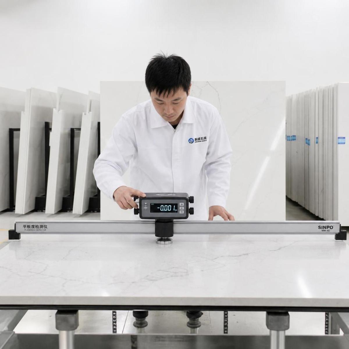 Quartz slabs standing on industrial A-frame storage racks in a stone factory warehouse