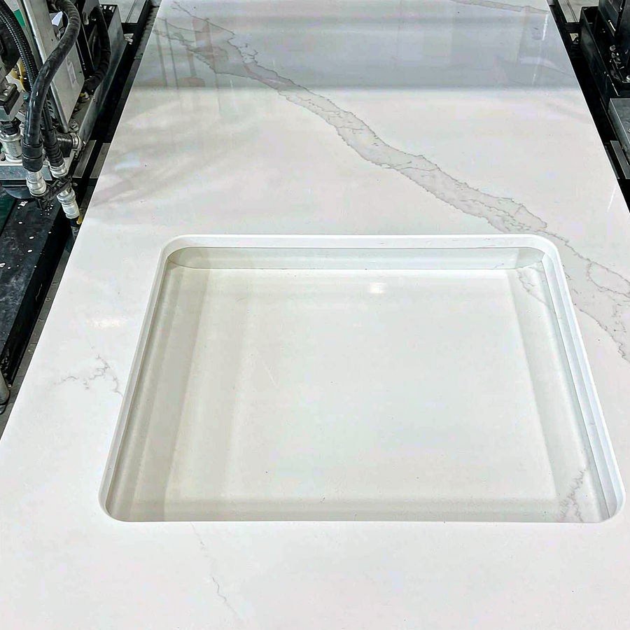 White quartz vanity tops with undermount sink cut-outs on production line