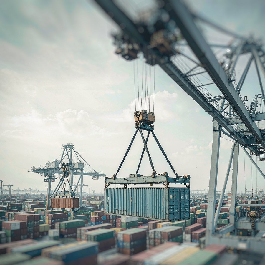A gantry crane lifting containers at a seaport — where a quartz slab FOB shipment changes hands